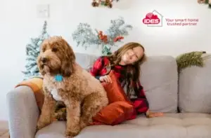 child and dog on couch with festive decorations in background - ides seasonal smart home